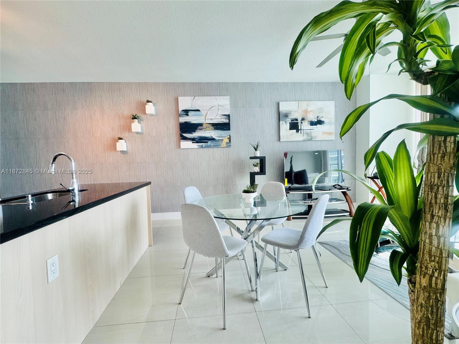 79 Southwest 12th Street, Unit 3211S Miami, FL 33130 - Photo 5 of 32 a dining room with furniture and a potted plant