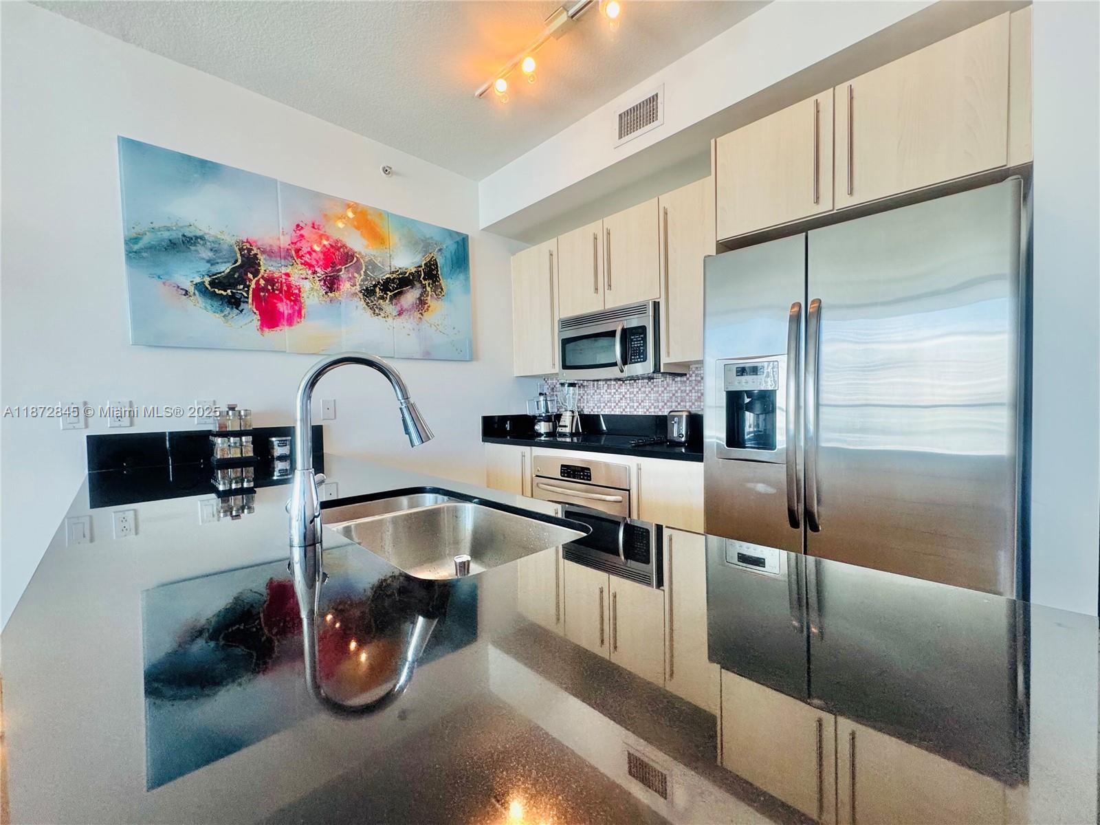 79 Southwest 12th Street, Unit 3211S Miami, FL 33130 - Photo 8 of 32 a kitchen with microwave a refrigerator and a sink