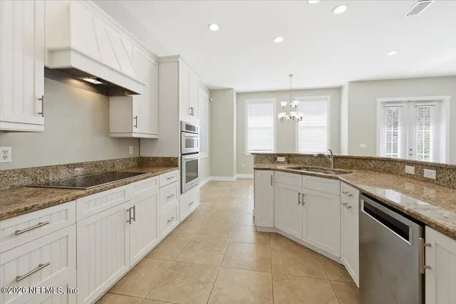 a large kitchen with granite countertop a sink and dishwasher a stove with wooden floors