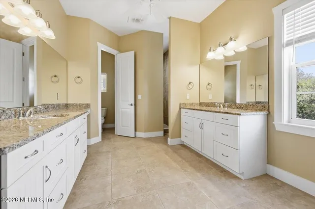 a spacious bathroom with a granite countertop sink mirror and a shower