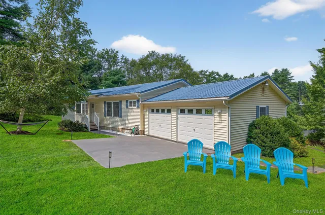 a view of a house with a yard and chairs