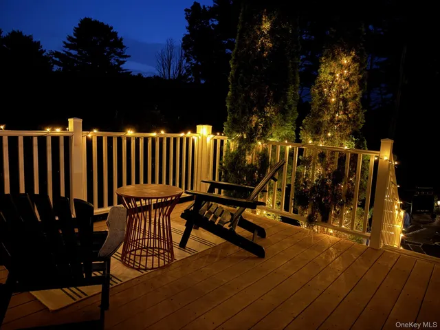 a balcony with wooden floor table and chairs