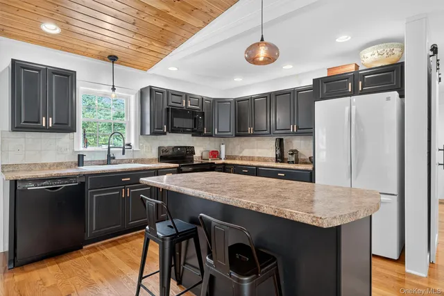 a kitchen with stainless steel appliances granite countertop a sink refrigerator stove microwave and cabinets