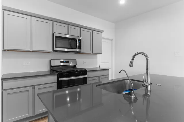 a kitchen with stainless steel appliances granite countertop a sink and a stove