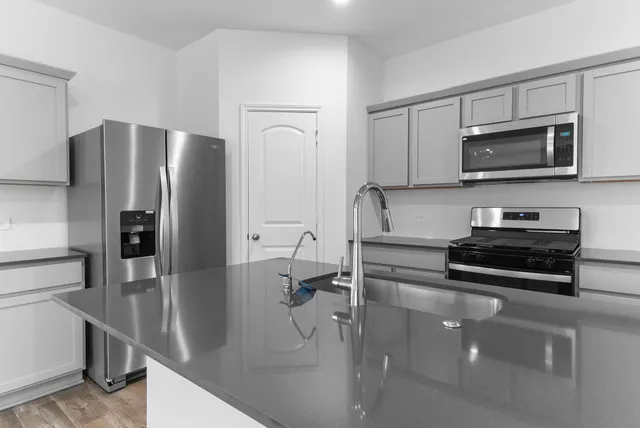 a kitchen with stainless steel appliances and a refrigerator
