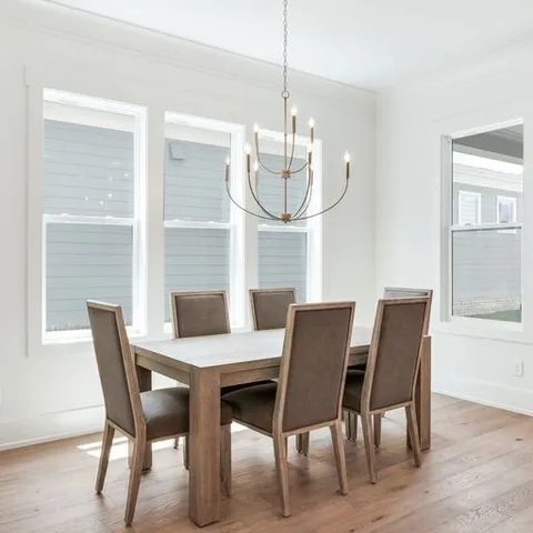 a view of a dining room with furniture a chandelier and wooden floor