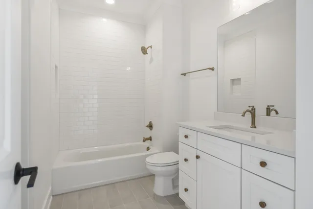 a bathroom with a granite countertop toilet a sink and a bathtub