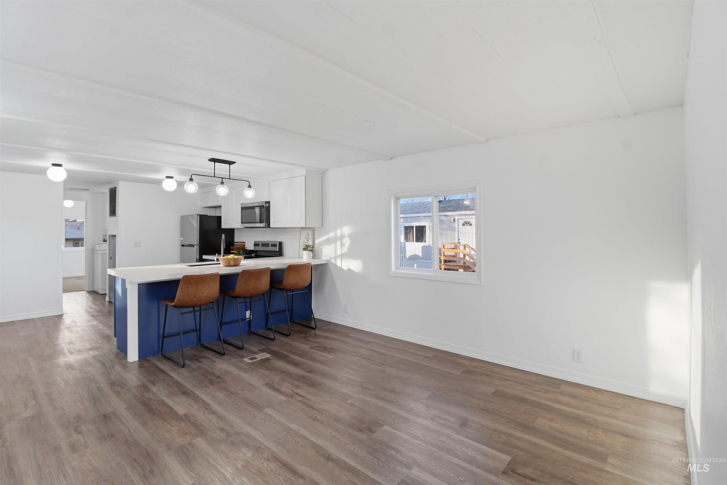 198 South Hills Road, Unit 43 Twin Falls, ID 83301 - Photo 6 of 25 Kitchen featuring a kitchen breakfast bar, light countertops, white cabinetry, a peninsula, and pendant lighting