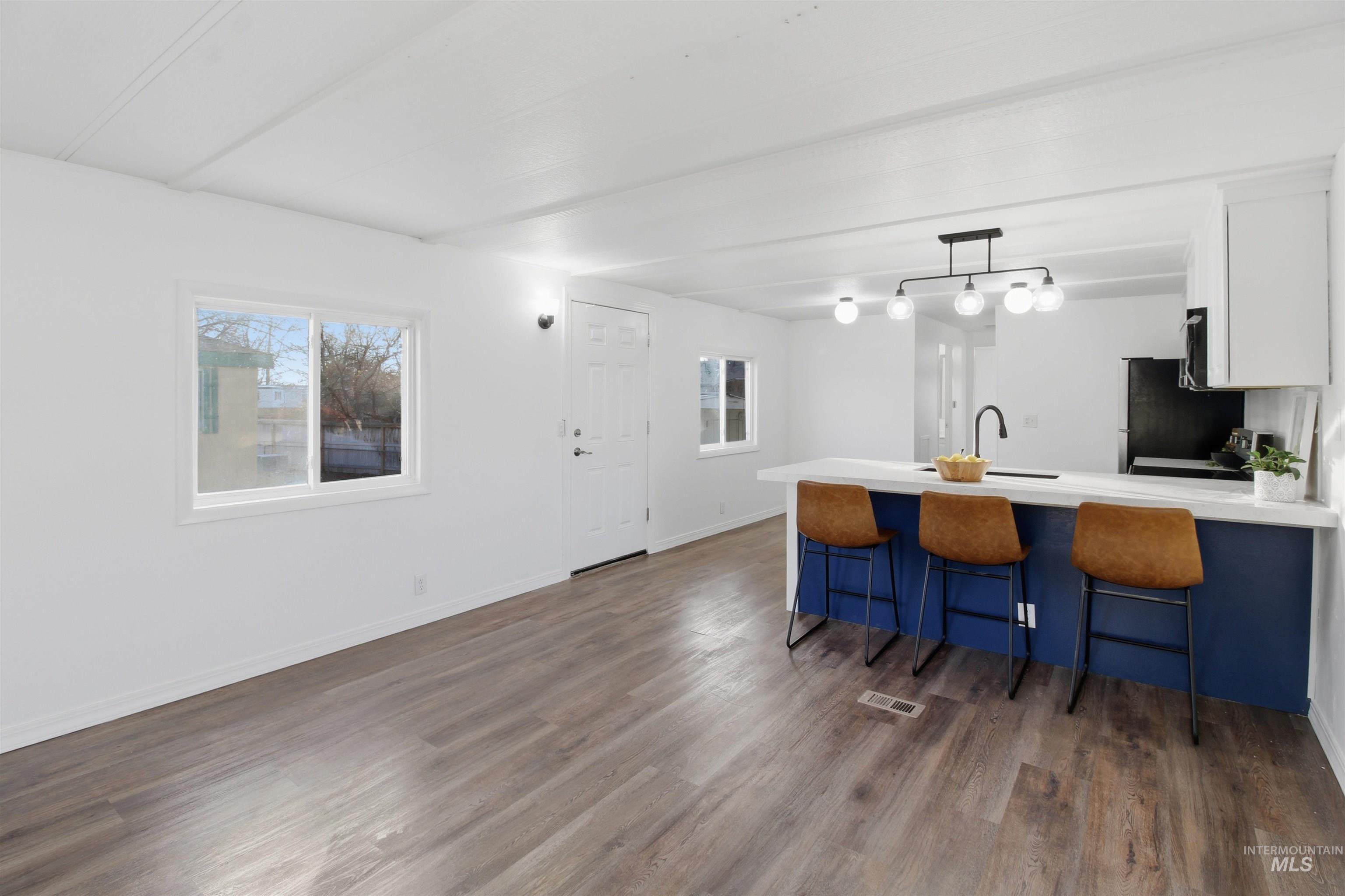 198 South Hills Road, Unit 43 Twin Falls, ID 83301 - Photo 9 of 25 Kitchen with a breakfast bar area, decorative light fixtures, a peninsula, white cabinetry, and dark wood-style floors