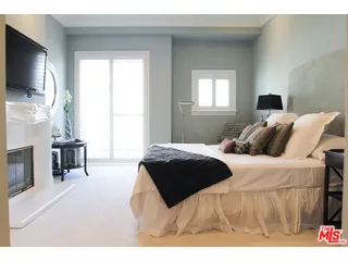 a bedroom with a bed and a flat tv screen on the dresser