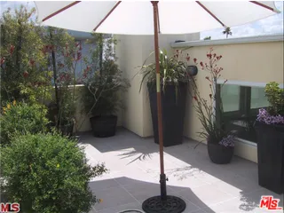 a vase of flowers sitting on a table in front of a house