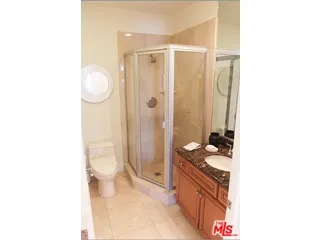 a bathroom with a granite countertop sink a toilet and shower