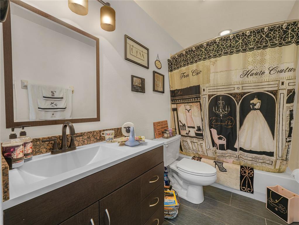 414 Eagle Ridge Drive, Unit 414 Davenport, FL 33837 - Photo 13 of 28 a bathroom with a toilet a sink and mirror