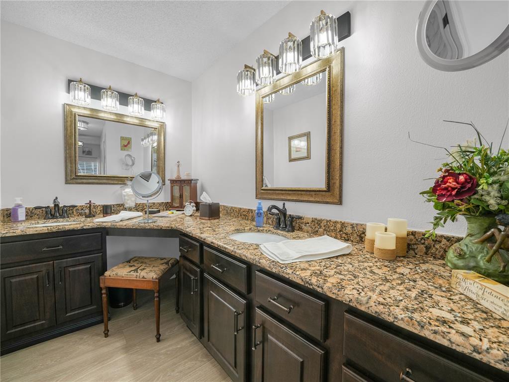 414 Eagle Ridge Drive, Unit 414 Davenport, FL 33837 - Photo 16 of 28 a bathroom with a granite countertop sink and a mirror