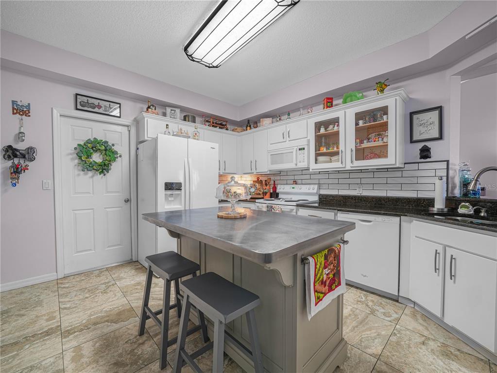 414 Eagle Ridge Drive, Unit 414 Davenport, FL 33837 - Photo 8 of 28 a kitchen with stainless steel appliances granite countertop a sink stove and refrigerator