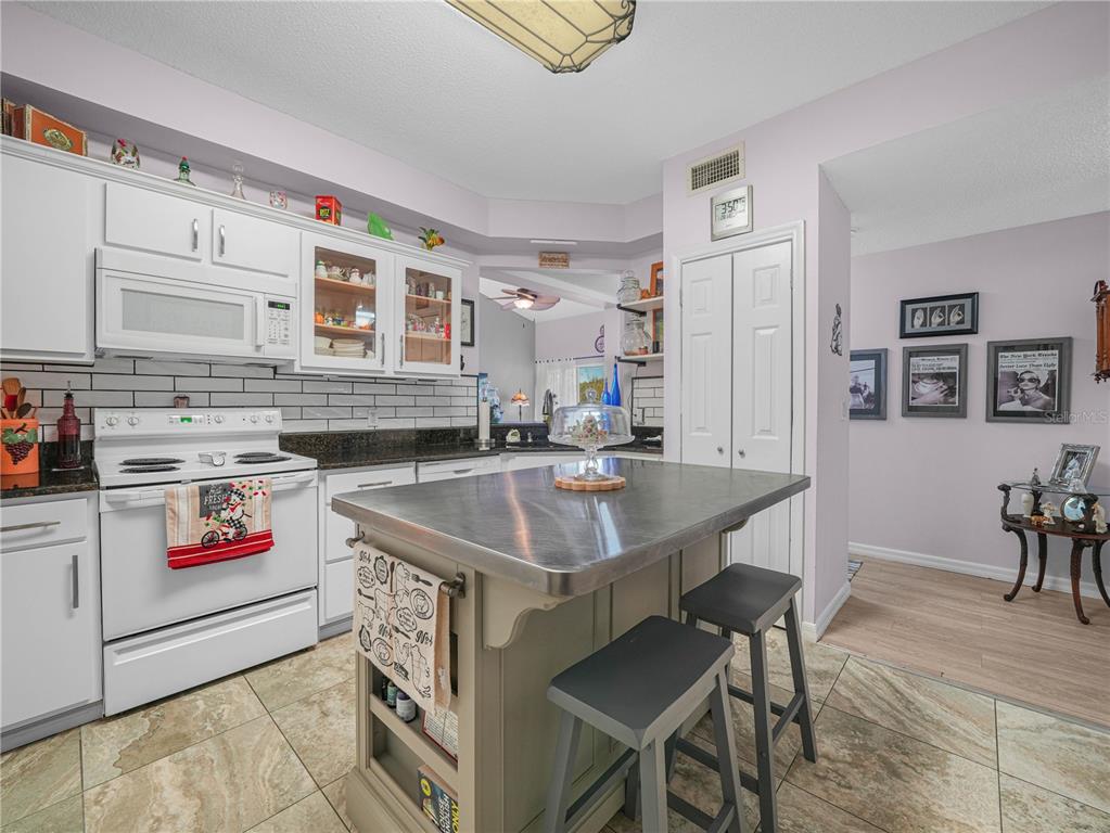 414 Eagle Ridge Drive, Unit 414 Davenport, FL 33837 - Photo 9 of 28 a kitchen with stainless steel appliances granite countertop a sink stove and cabinets