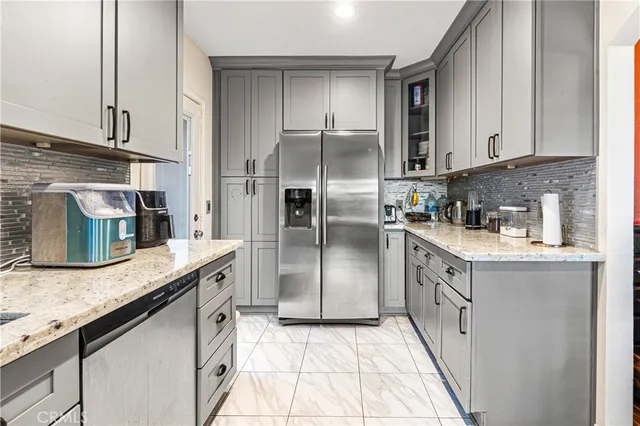 a kitchen with stainless steel appliances granite countertop a sink a stove and a refrigerator