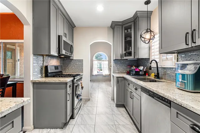a kitchen with granite countertop a sink a stove and cabinets