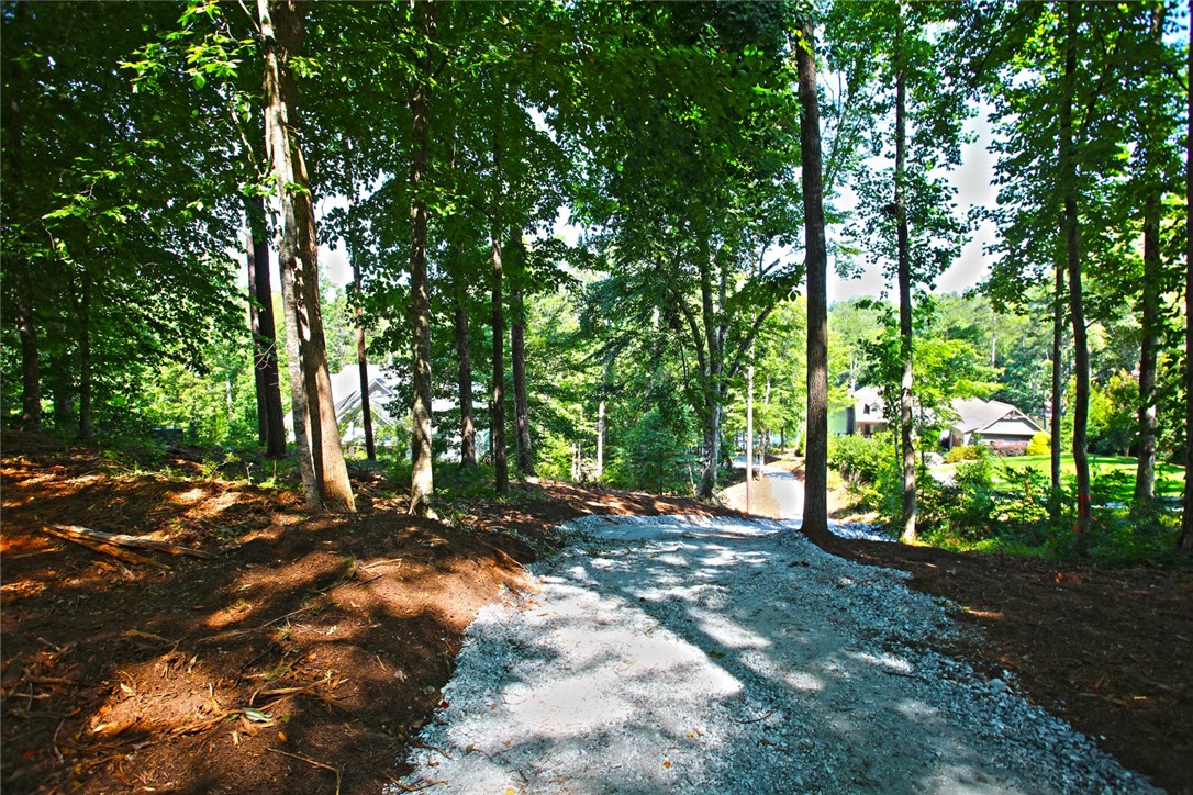 1359 Hbr Rdg Road Seneca, SC 29672 - Photo 11 of 39 A tranquil gravel path winds through verdant trees, leading to glimpses of serene water.