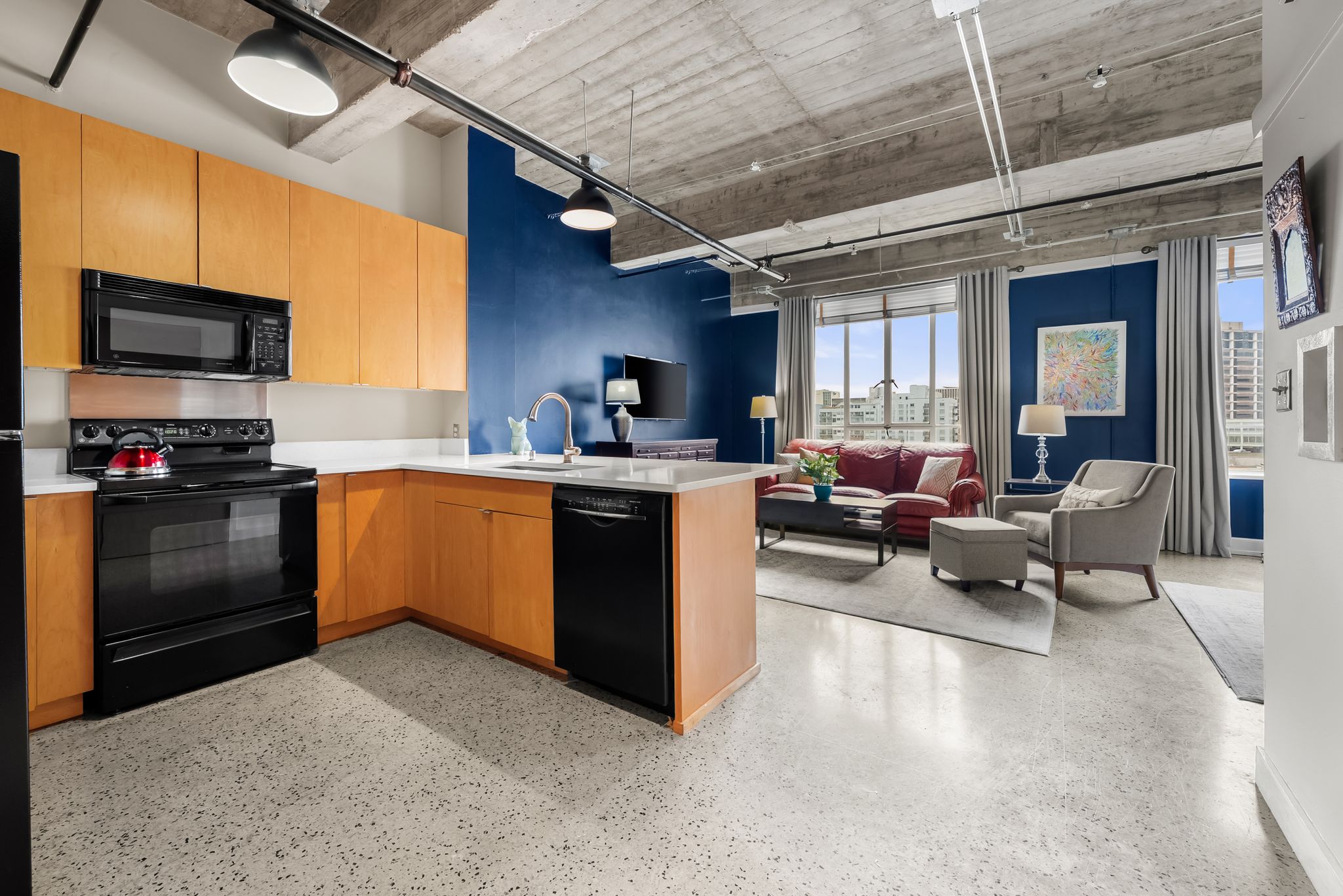 710 Colorado Street, Unit 6E Austin, TX 78701 - Photo 1 of 24 An open concept living area boasts a modern kitchen and an inviting lounge space with city views.