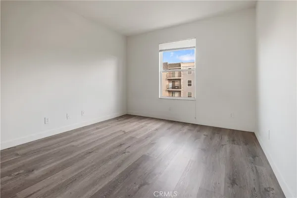 an empty room with wooden floor and window