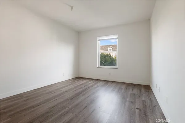 an empty room with wooden floor and a window