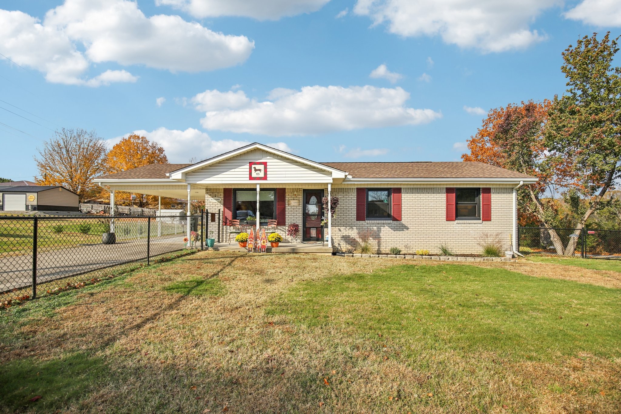a front view of a house with swimming pool and porch with furniture