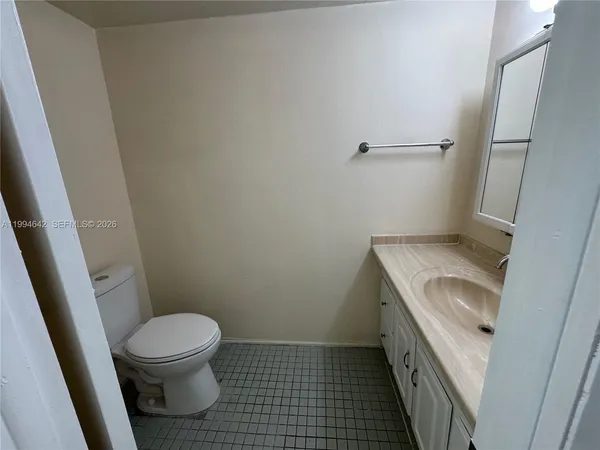a bathroom with a granite countertop toilet and a sink