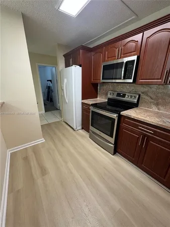 a kitchen with stainless steel appliances granite countertop a refrigerator and a stove