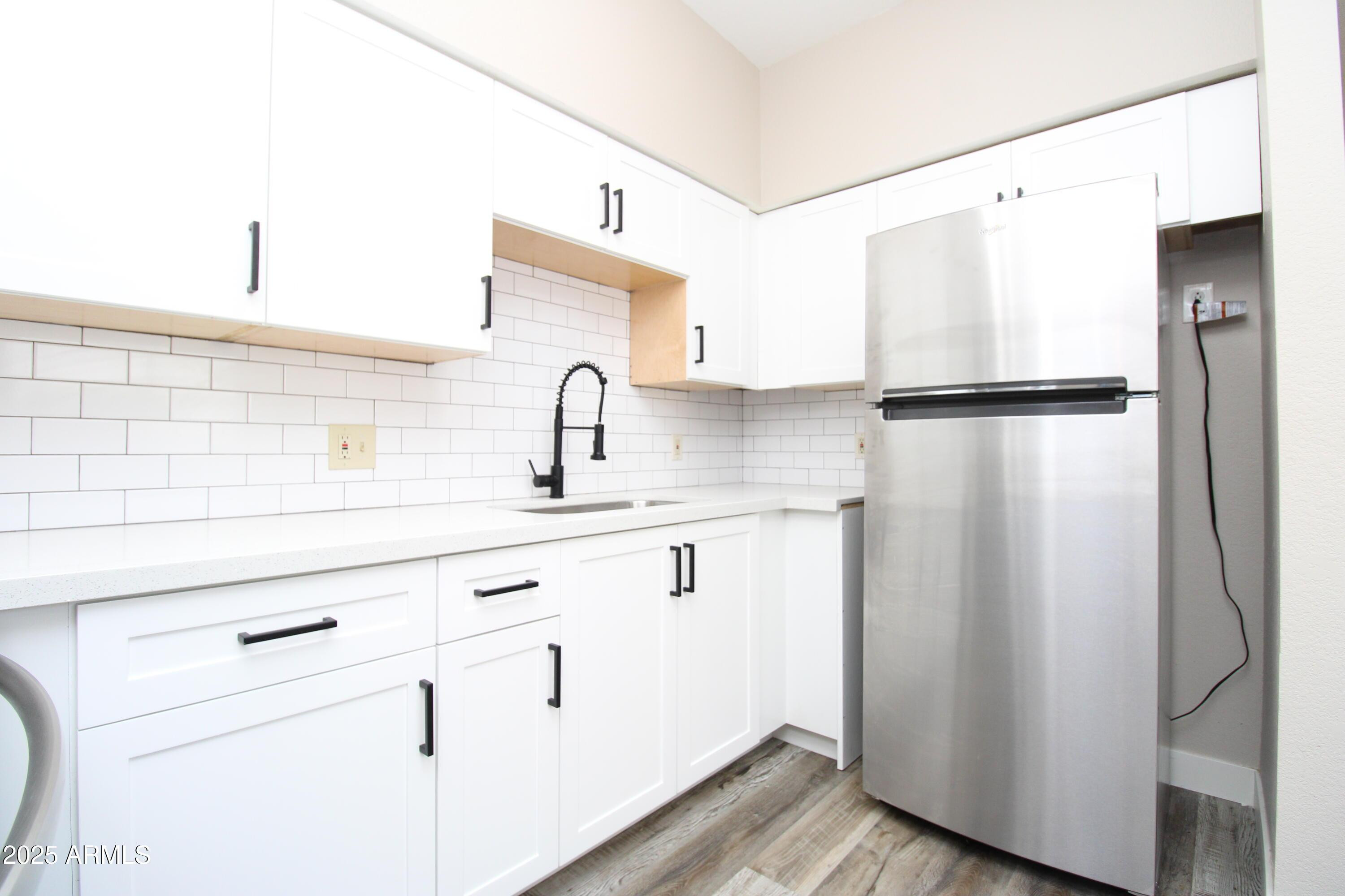 2807 East Paradise Lane, Unit 102 Phoenix, AZ 85032 - Photo 4 of 12 a kitchen with a refrigerator sink and cabinets