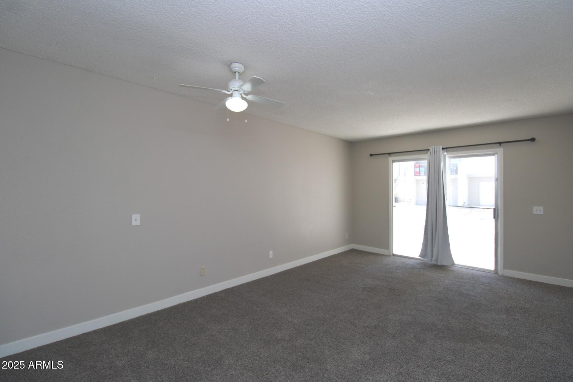 2807 East Paradise Lane, Unit 102 Phoenix, AZ 85032 - Photo 7 of 12 an empty room with a window and ceiling fan