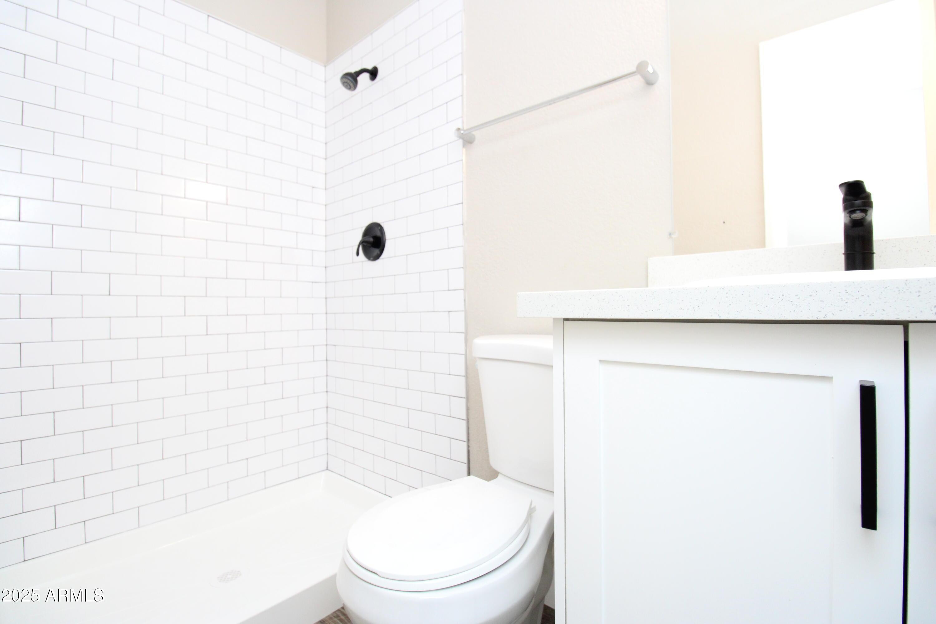 2807 East Paradise Lane, Unit 102 Phoenix, AZ 85032 - Photo 10 of 12 a white toilet sitting next to a bathroom sink