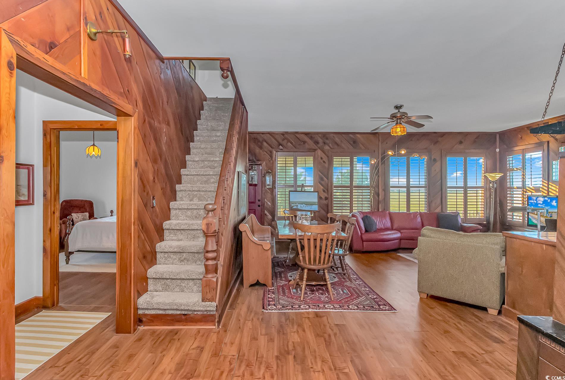 1417 Inlet Street Sunset Beach, NC 28468 - Photo 13 of 36 Living room with wood walls, ceiling fan, and ligh