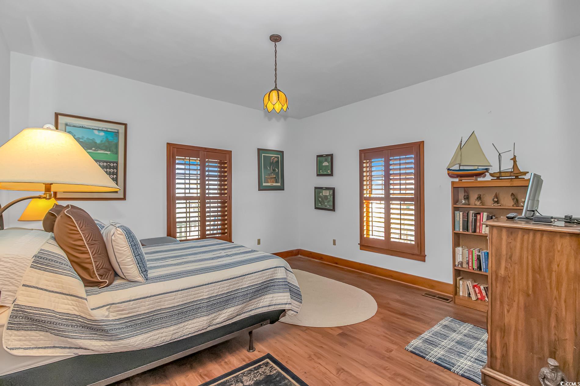 1417 Inlet Street Sunset Beach, NC 28468 - Photo 17 of 36 Bedroom with wood-type flooring and multiple windo