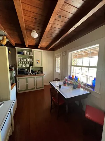 a view of a hallway with cabinets and wooden floor
