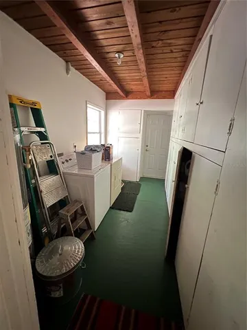 a view of a pool with a lawn chairs and a large tree