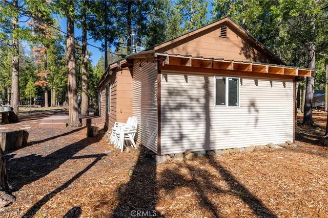 a front view of a house with a yard and trees