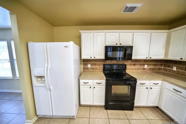 a kitchen with a stove a refrigerator and a sink