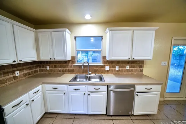 a kitchen with stainless steel appliances granite countertop a sink stove and cabinets