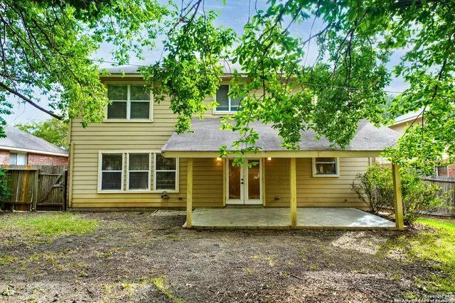 a view of a yard in front of a house with large trees
