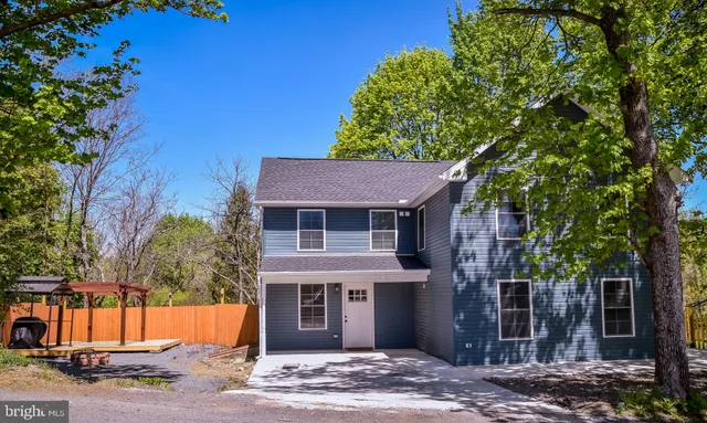 a view of a house with a tree and wooden fence