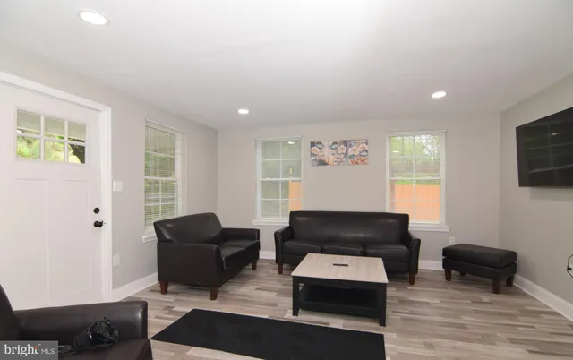 a living room with furniture and a wooden floor