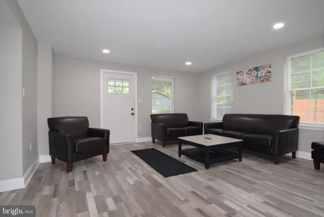 a living room with furniture a flat screen tv and kitchen view