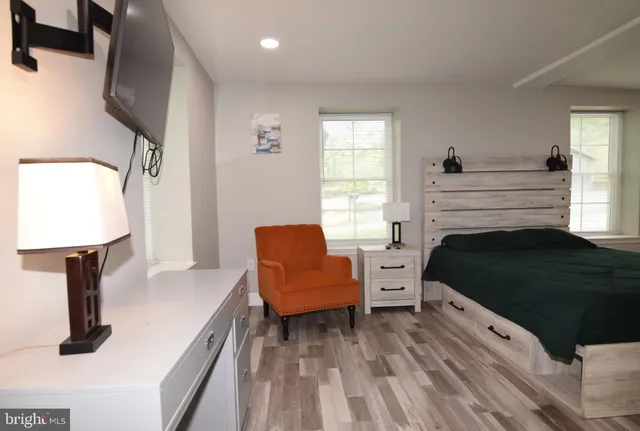 a view of a bedroom with cabinet mirror and bedroom lamp