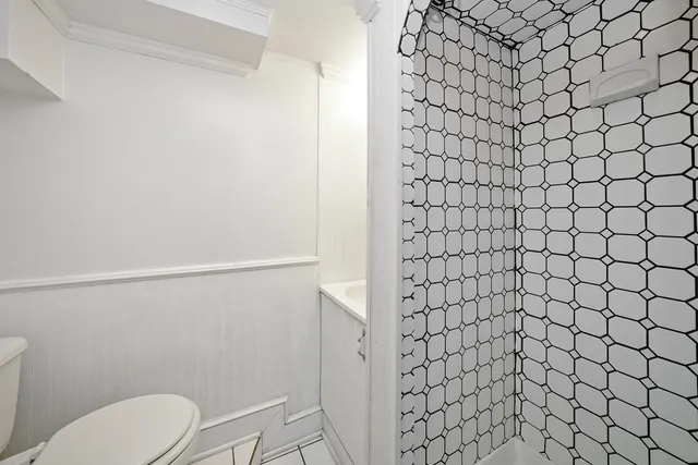 a bathroom with a toilet and a shower curtain
