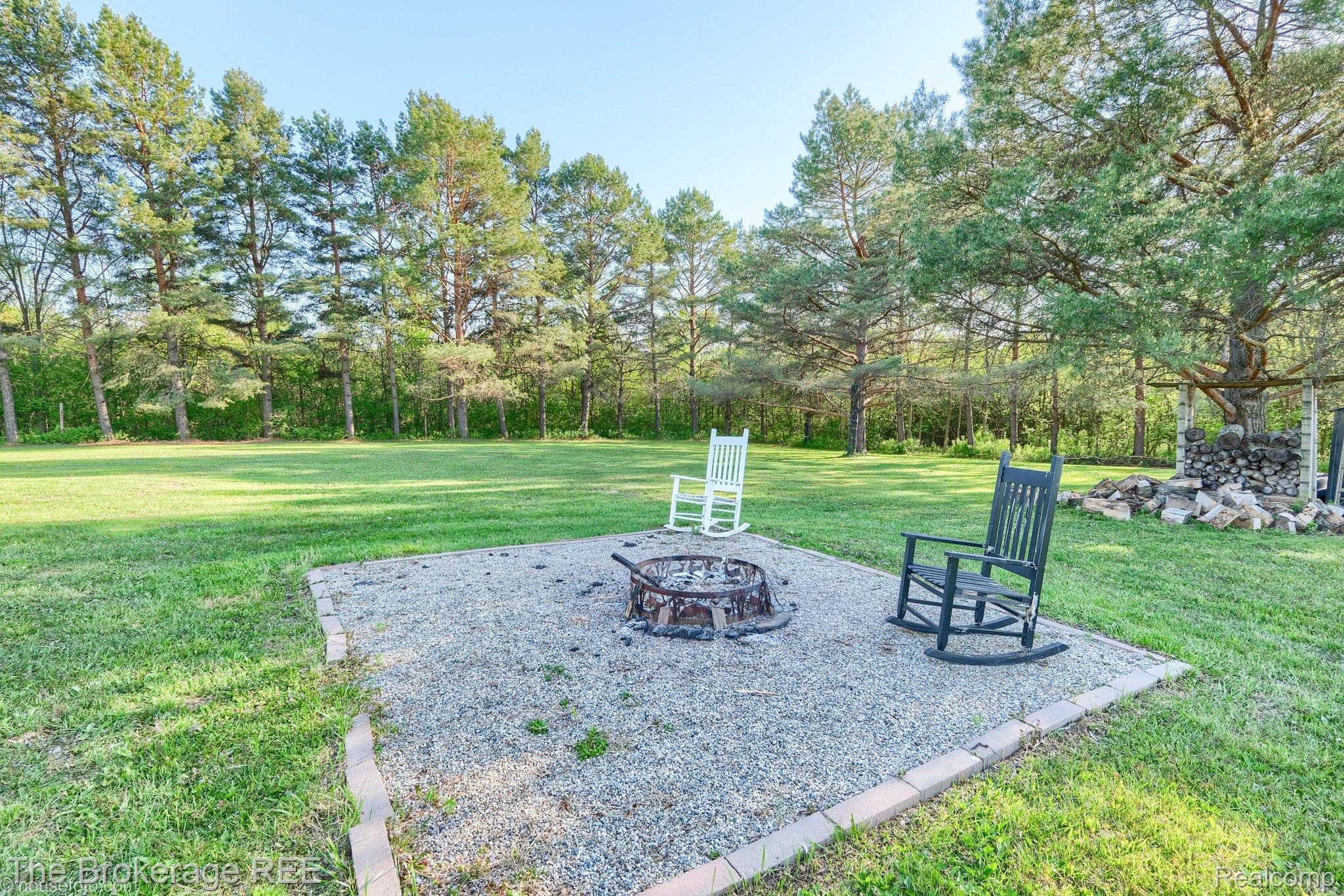 6288 Porter Road Grand Blanc, MI 48439 - Photo 4 of 39 View of green lawn with an outdoor fire pit and a patio