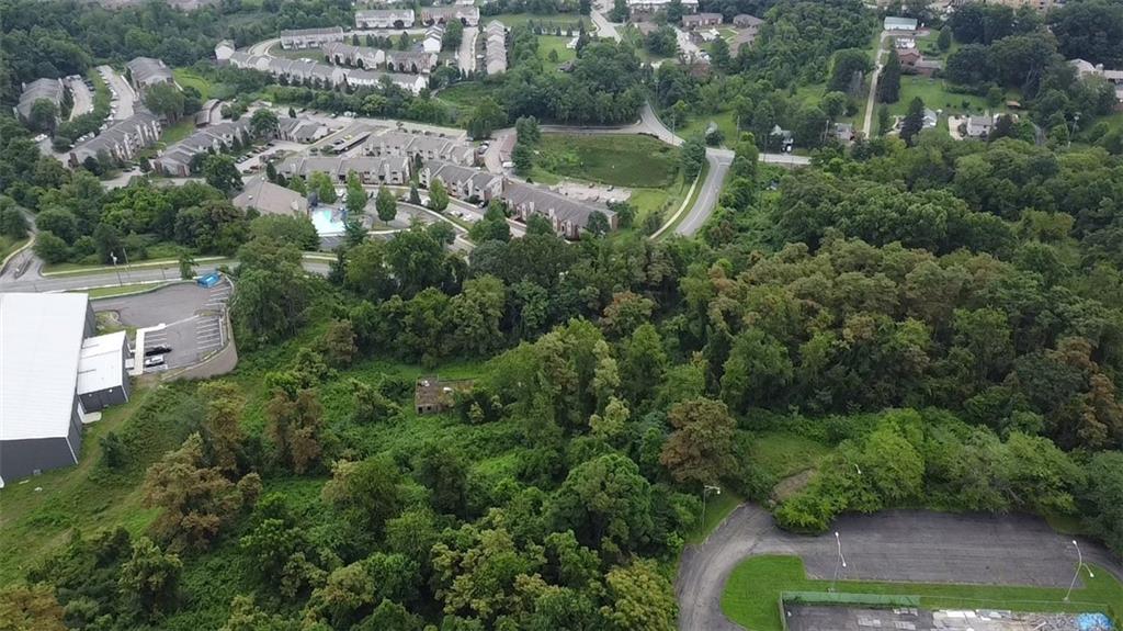 an aerial view of residential house with outdoor space and trees all around
