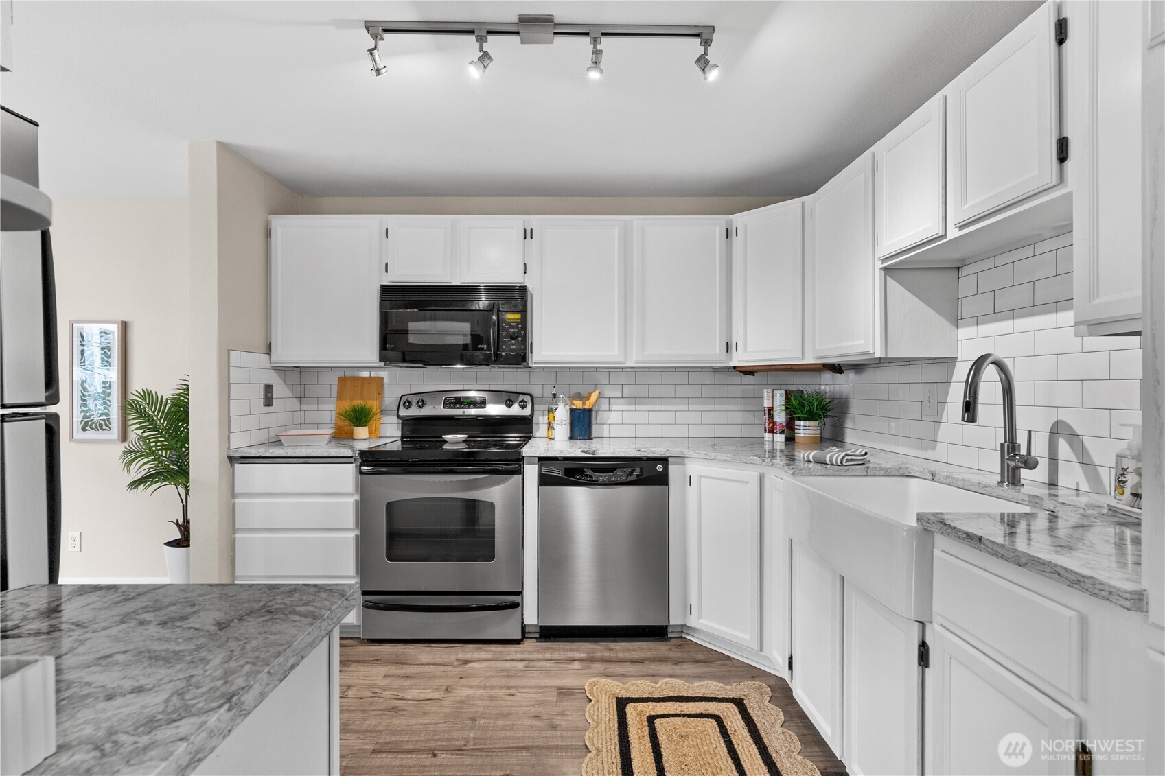8720 Phinney Avenue North, Unit 11 Seattle, WA 98103 - Photo 3 of 28 a kitchen with stainless steel appliances granite countertop a stove a sink and a microwave