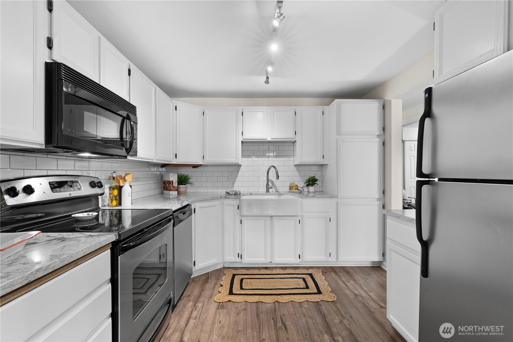 8720 Phinney Avenue North, Unit 11 Seattle, WA 98103 - Photo 8 of 28 a kitchen with a sink stainless steel appliances and white cabinets