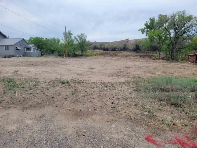 a view of a field with trees in background